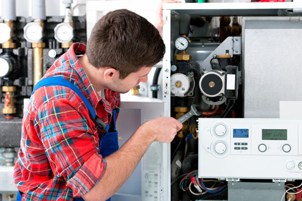 Heating technician repairing boiler controls in Lawndale