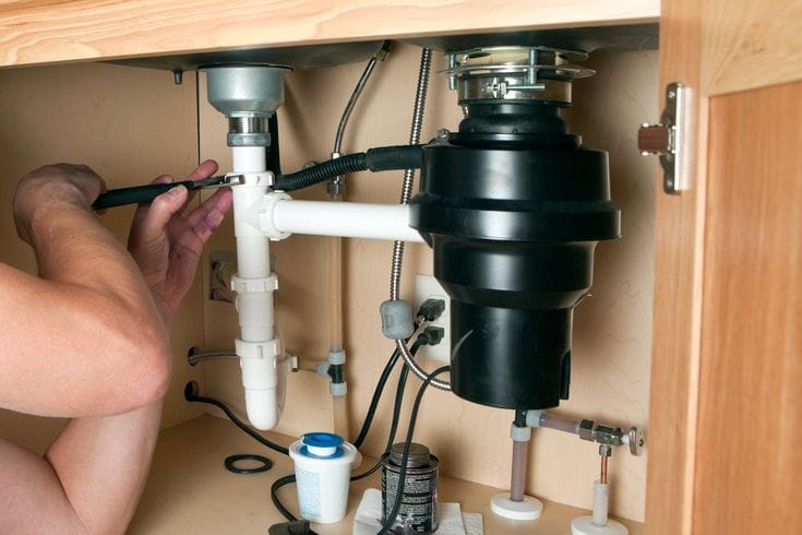 Plumber repairing a garbage disposal in Lawndale