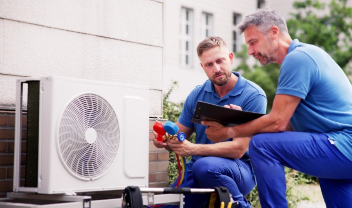 HVAC technicians installing an outdoor air conditioning unit in Lawndale