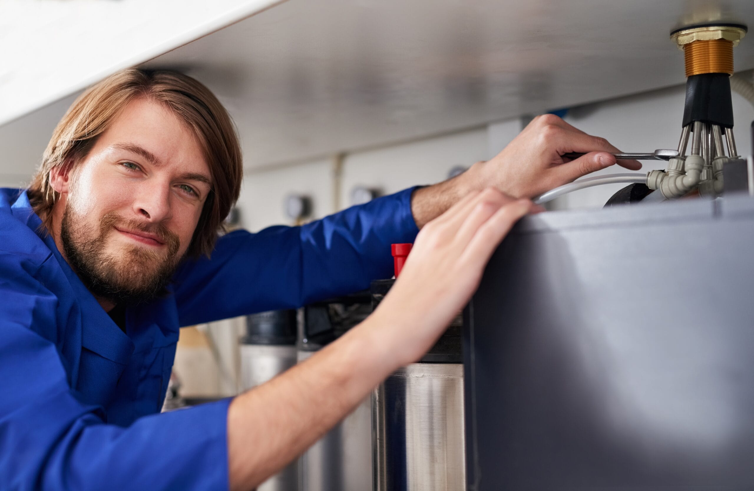 Technician servicing a residential water heater tank in Lawndale
